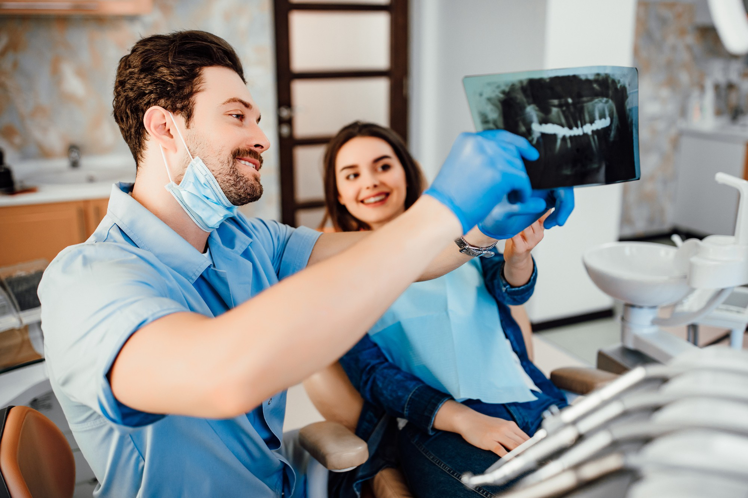 dentistry-healthcare-concept-male-dentist-showing-teeth-x-ray-female-patient-dental-white-clinic-room